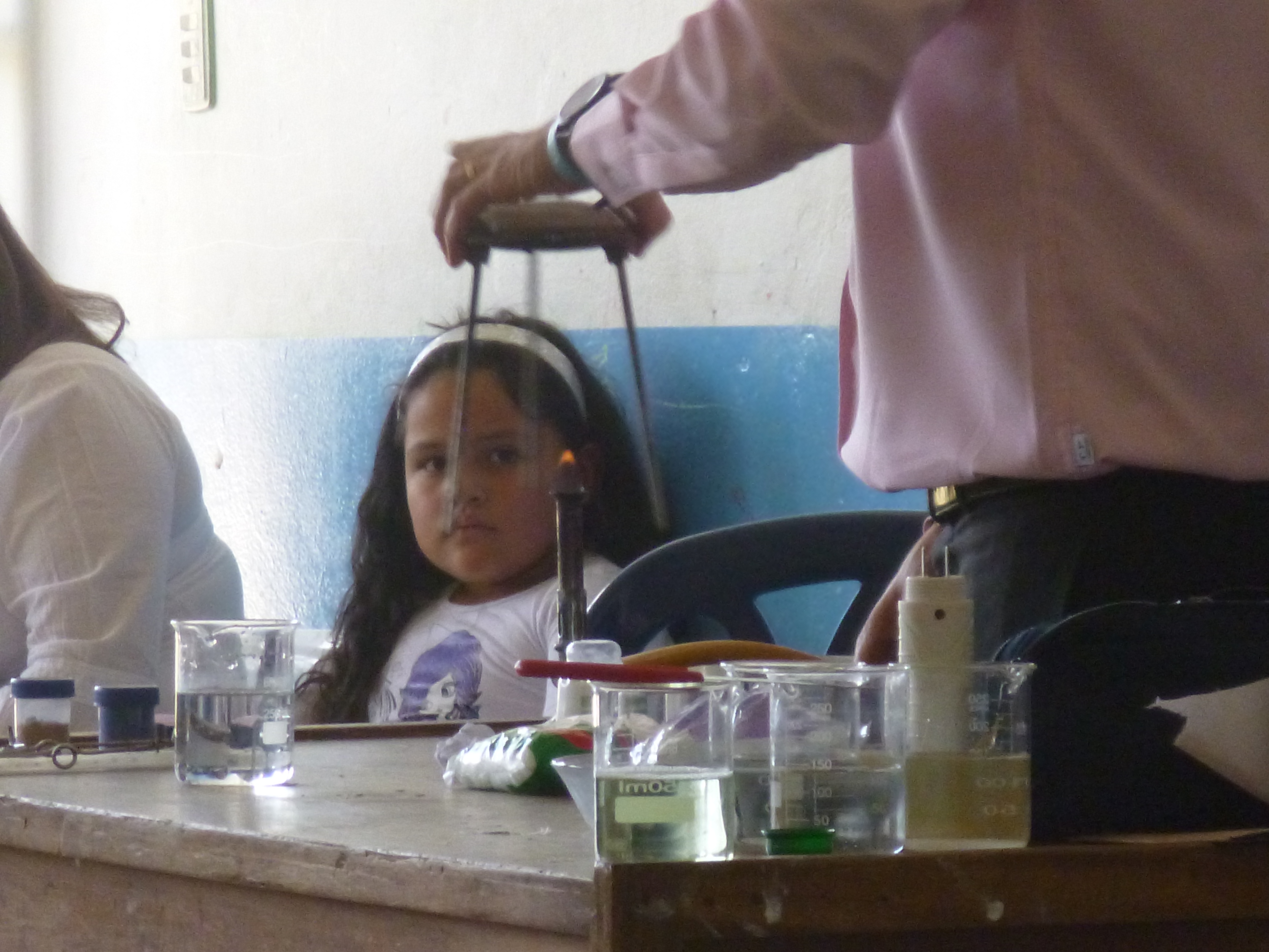 Alumna concentrada viendo experimentos junto al profesor Omar Alejandro